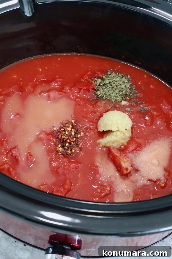 Slow Cooker Meatballs with Marinara Sauce Recipe 5 tomato sauce in slow cooker topped with spices and herbs