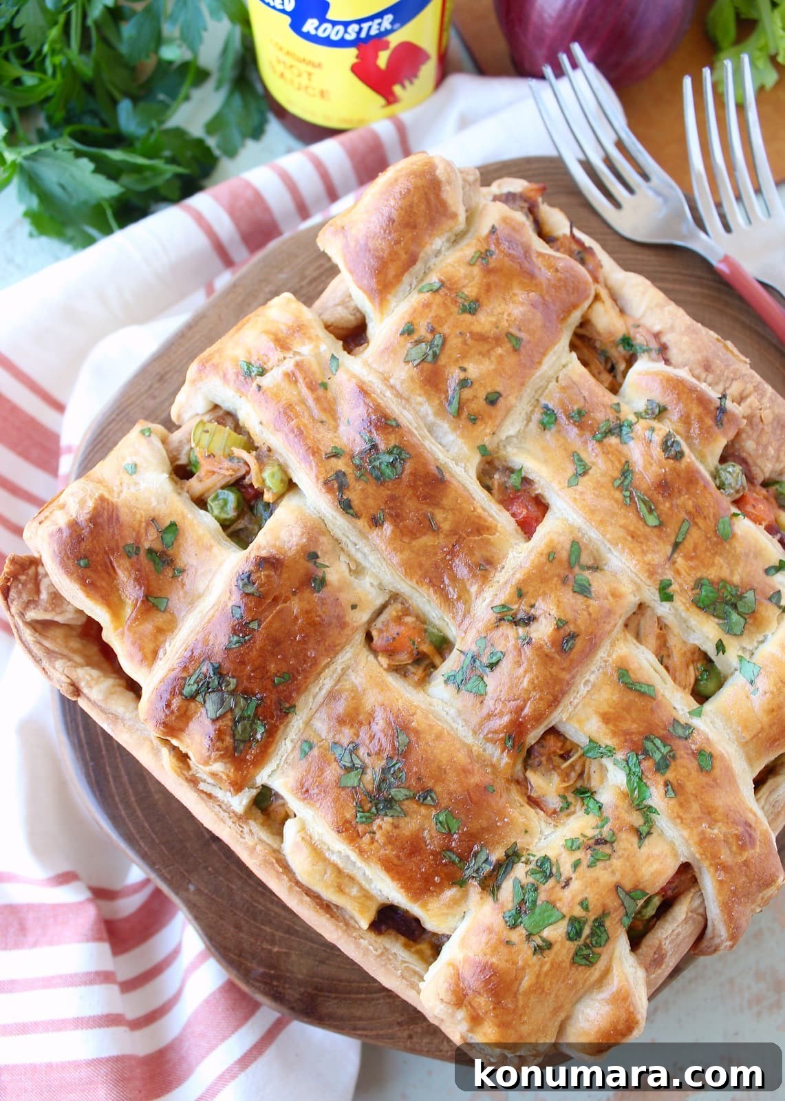 Savory Cajun Chicken Pot Pie Recipe 2 baked chicken pot pie with a braided puff pastry crust on a wood board