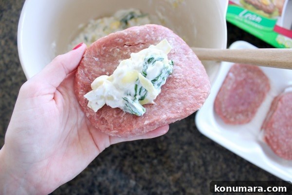 Spinach and Artichoke Turkey Burger Recipe 6 Spinach Artichoke dip stuffed in a turkey burger patty with a hand holding it