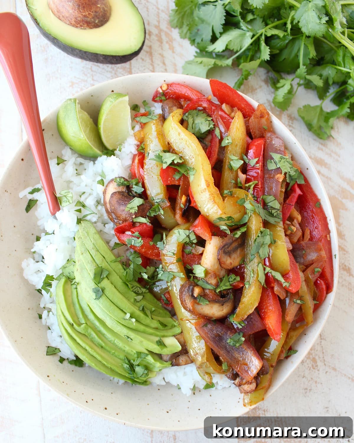 Vegetarian Fajita Rice Bowl with Peppers and Black Beans 5 veggie fajitas on top of cooked white rice in a bowl with sliced avocado
