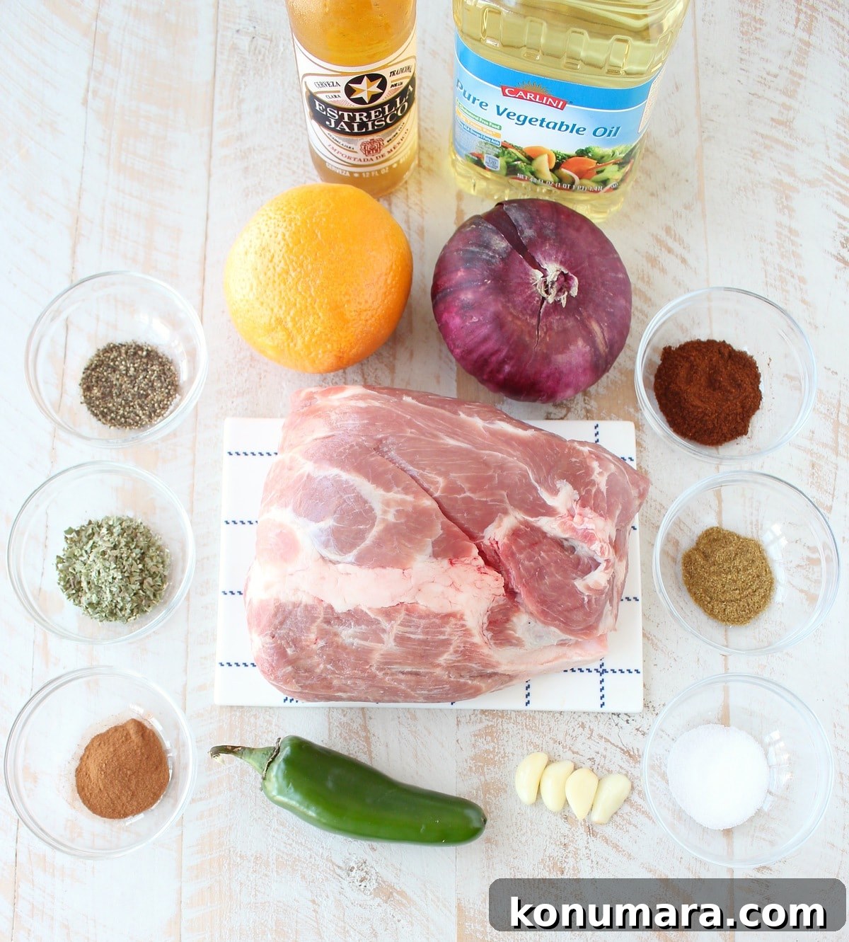 Ingredients for slow cooker carnitas on white wood board
