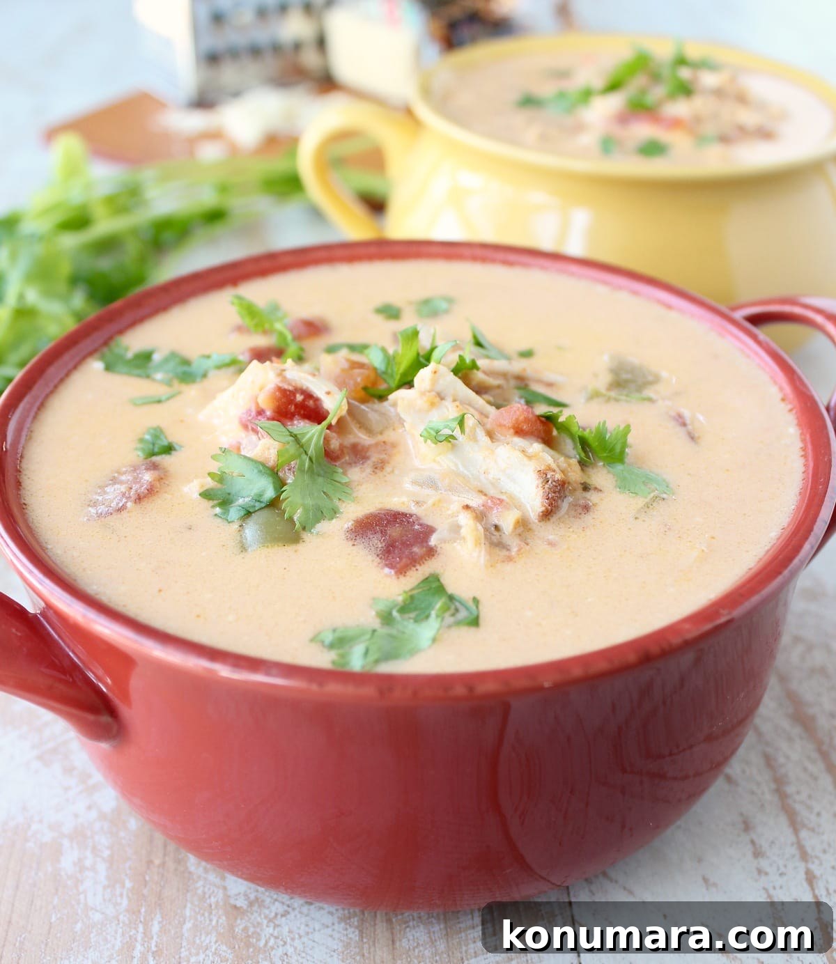 Slow Cooker Cheesy Turkey Taco Soup Recipe 2 A red bowl on a wooden surface filled with Cheesy Turkey Taco Soup.