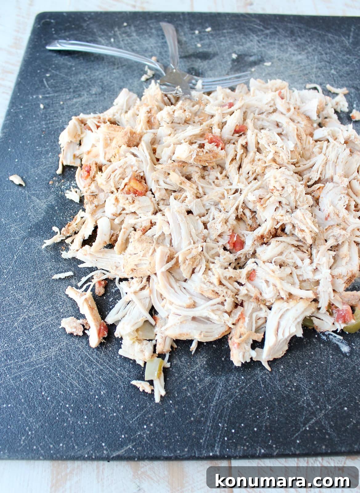 Slow Cooker Cheesy Turkey Taco Soup Recipe 6 Shredded turkey on a black cutting board.