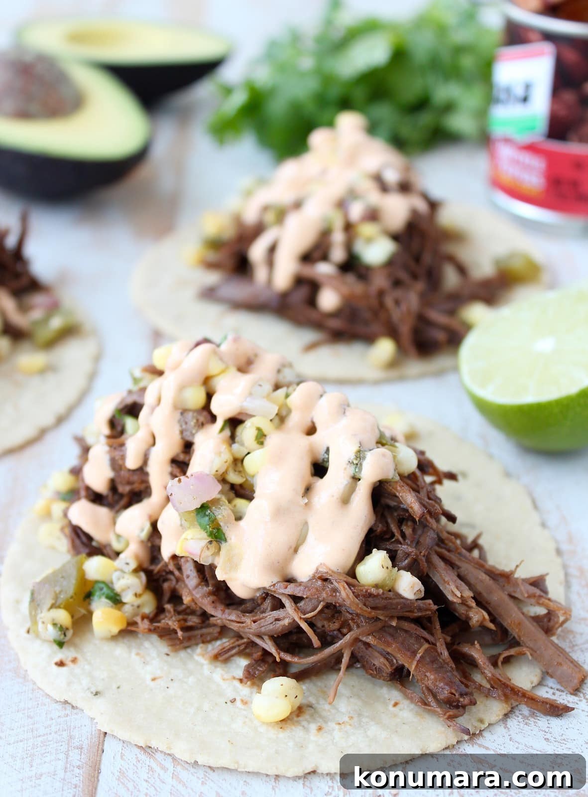 Slow Cooker Smoky Chipotle Brisket Tacos 2 shredded brisket tacos topped with corn salsa and creamy chipotle sauce