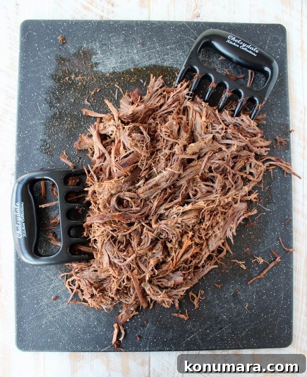 Slow Cooker Smoky Chipotle Brisket Tacos 5 shredded brisket on cutting board with meat claws