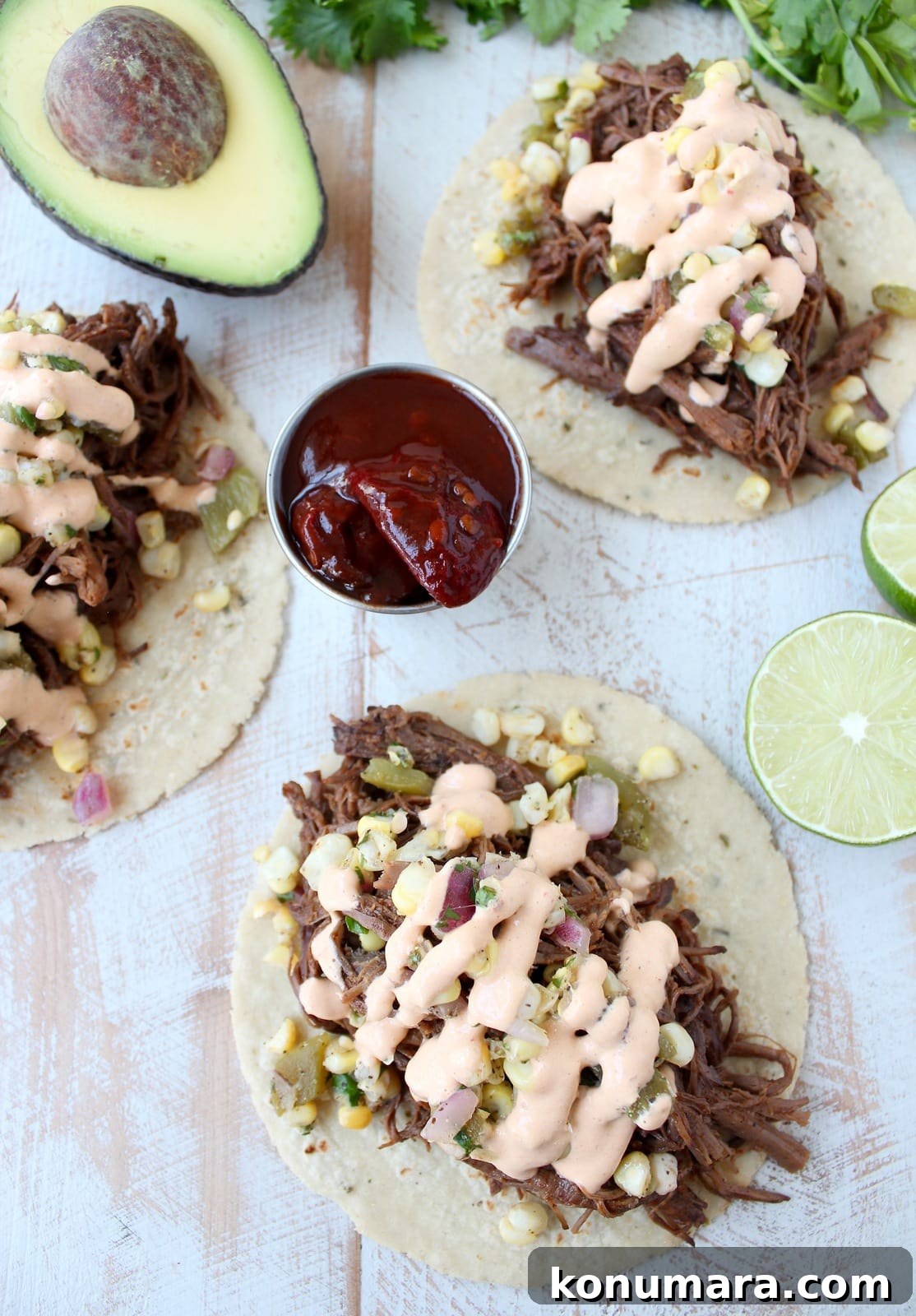 Slow Cooker Smoky Chipotle Brisket Tacos 7 shredded cooked brisket on corn tortillas topped with corn salsa and chipotle sauce
