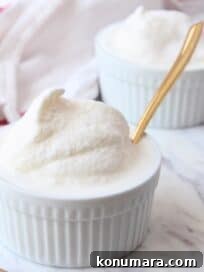 Vanilla ice cream in white ramekin with gold spoon