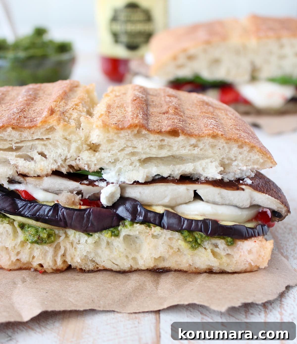 Crispy Grilled Vegetarian Panini Recipes 2 Vegetarian Italian Panini on a piece of paper on a white wood board