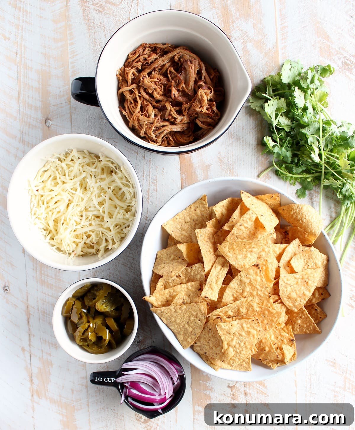 Loaded Pulled Pork Nachos Recipe with Tangy BBQ Sauce 3 The Ultimate Pulled Pork Nachos Recipe Ingredients in bowls; chips, sliced red onions, jalapeños, cheese, pulled pork, and cilantro