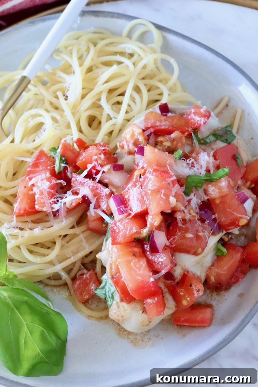 Bruschetta Chicken Recipe with Basil and Balsamic Glaze 10 chicken topped with tomato bruschetta on a plate with cooked spaghetti noodles