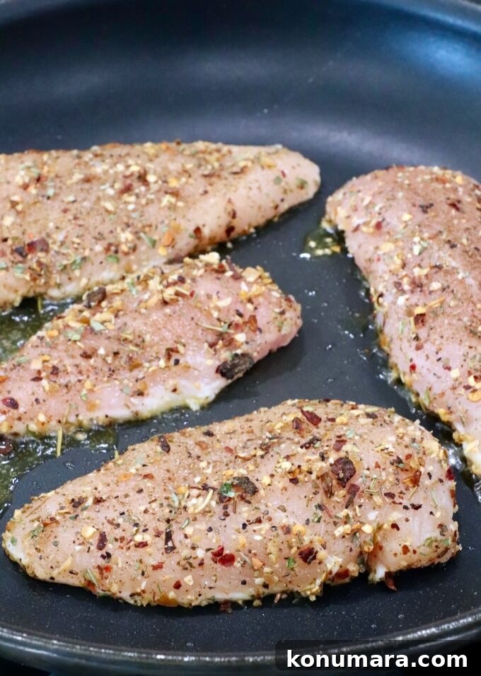 Bruschetta Chicken Recipe with Basil and Balsamic Glaze 6 raw seasoned chicken breasts in a skillet