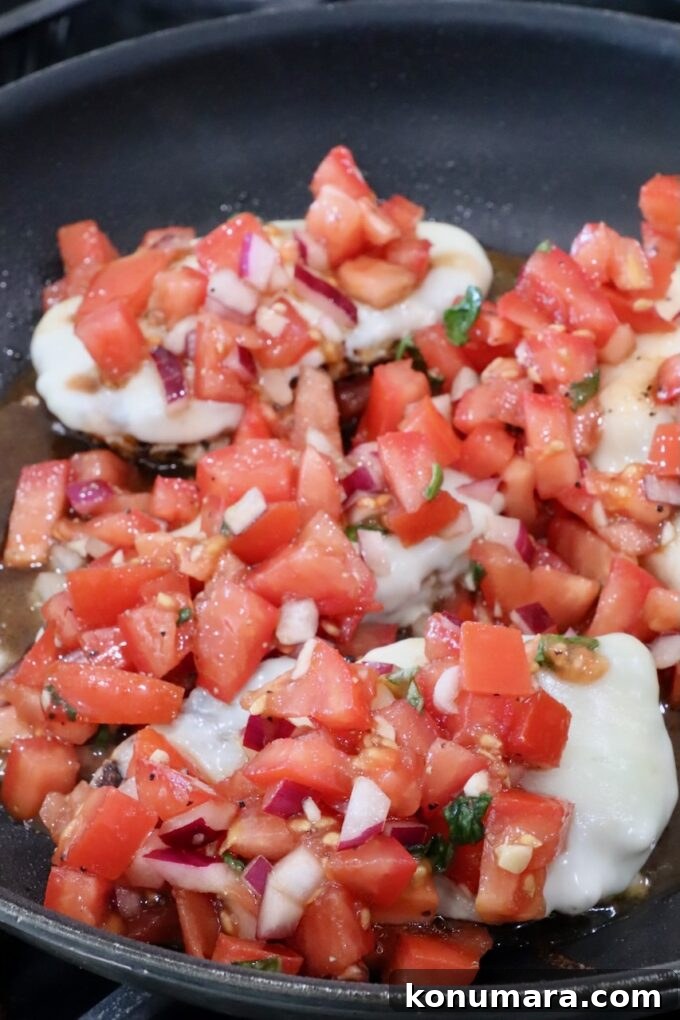 Bruschetta Chicken Recipe with Basil and Balsamic Glaze 9 tomato bruschetta on top of chicken breasts in a skillet