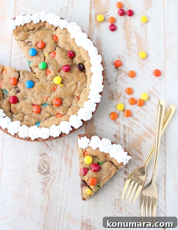 The Ultimate Candy Cookie Cake recipe is perfect for Halloween, birthdays or holidays, add your favorite candy to cookie dough & bake into a tasty cake!