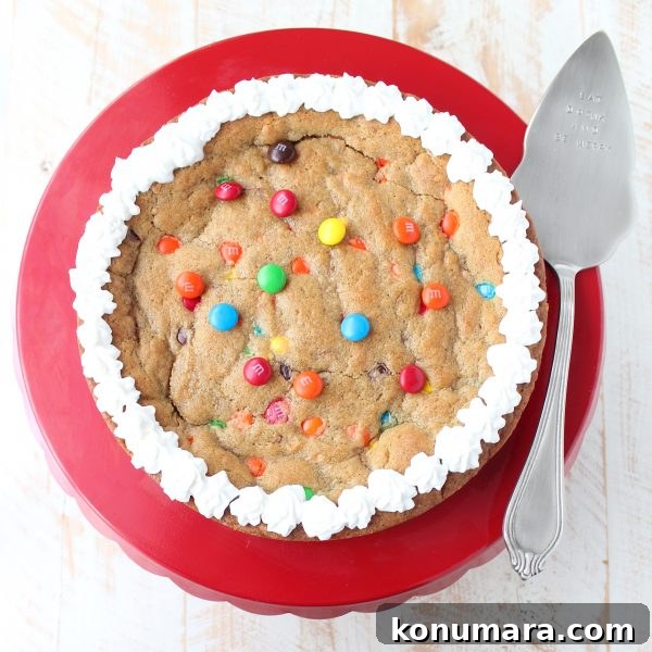 The Ultimate Candy Cookie Cake recipe is perfect for Halloween, birthdays or holidays, add your favorite candy to cookie dough & bake into a tasty cake!