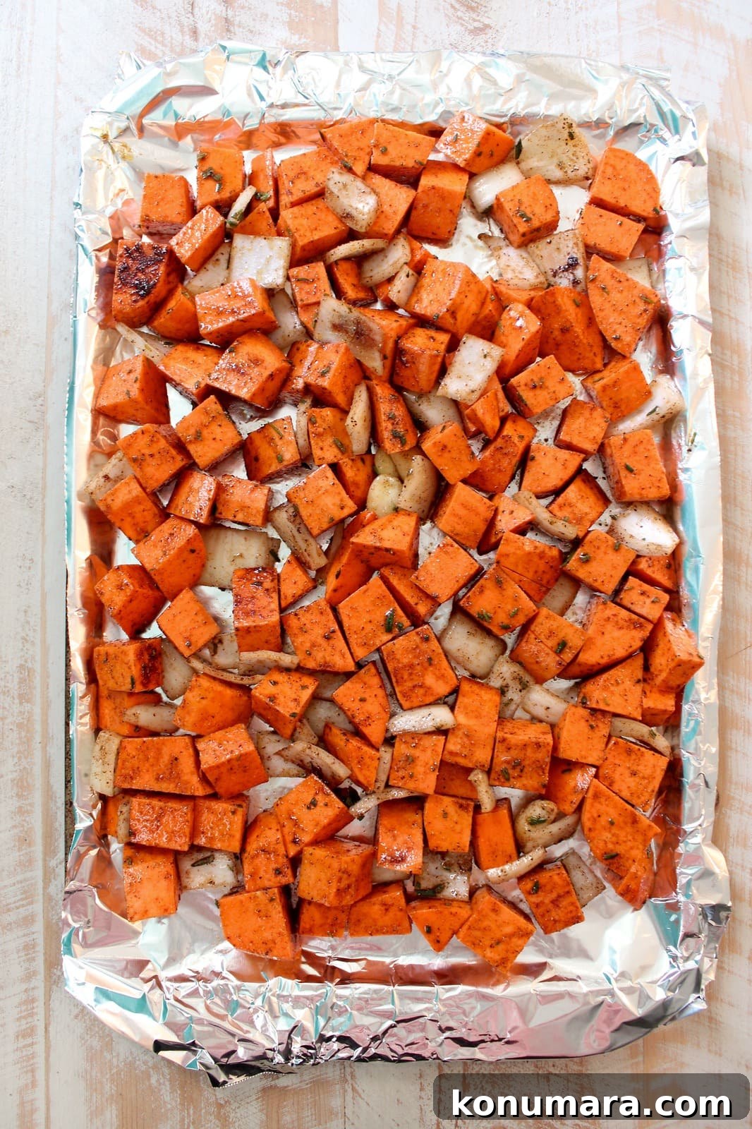 Creamy Roasted Sweet Potato Soup Recipe 4 cubed sweet potatoes with onion and garlic on a foil lined sheet pan