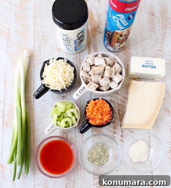 Cheesy Buffalo Chicken Bake Recipe 3 Ingredients for Buffalo Chicken Bake on a wooden surface divided in bowls and measuring cups.