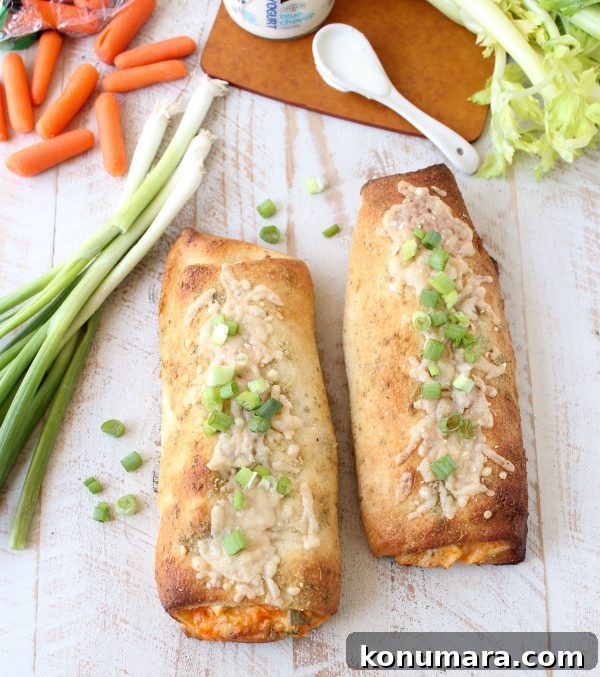 Cheesy Buffalo Chicken Bake Recipe 6 Two cooked Chicken Bakes on a wooden surface next to carrots and green onions.