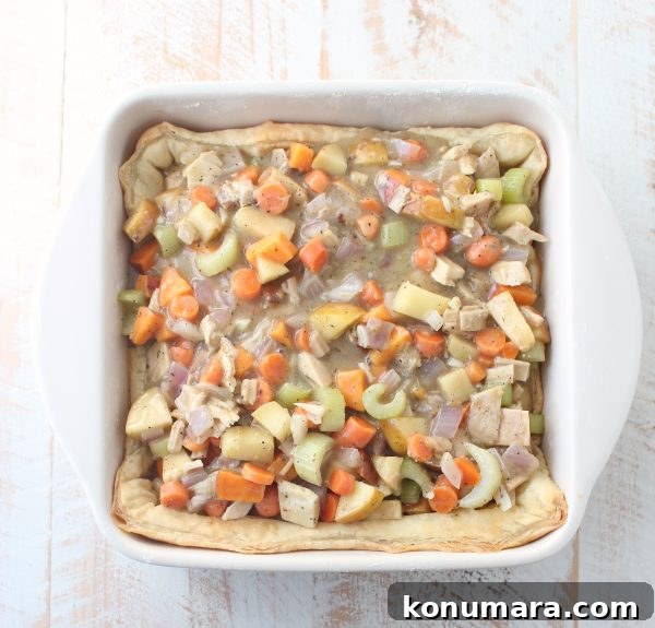 Flaky Puff Pastry Turkey Pot Pie 6 puff pastry dough covered with turkey pot pie filling in a square baking dish