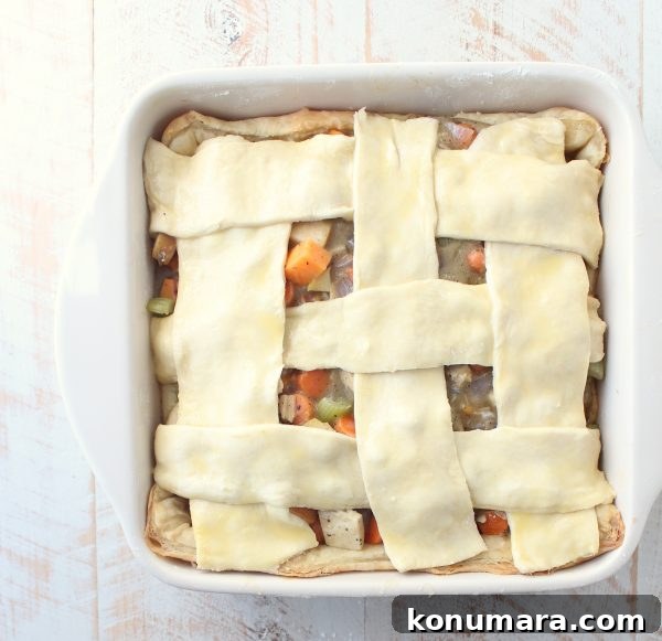 Flaky Puff Pastry Turkey Pot Pie 7 woven puff pastry dough on top of a turkey pot pie in a square baking dish