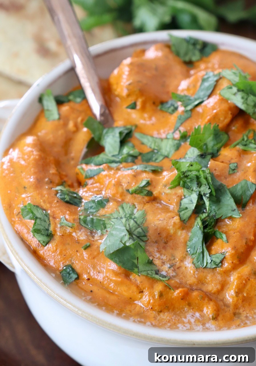 Authentic Indian Butter Chicken Recipe, Creamy and Rich 4 chicken makhani in white bowl with spoon
