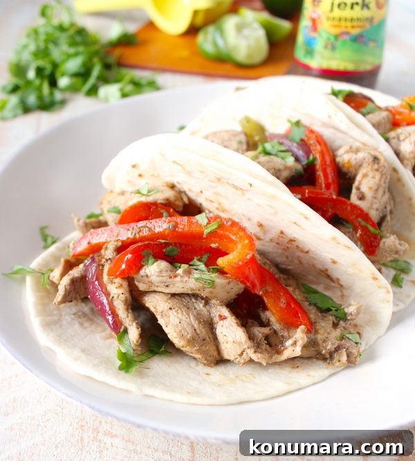 Close-up of jerk chicken fajita in a tortilla with toppings