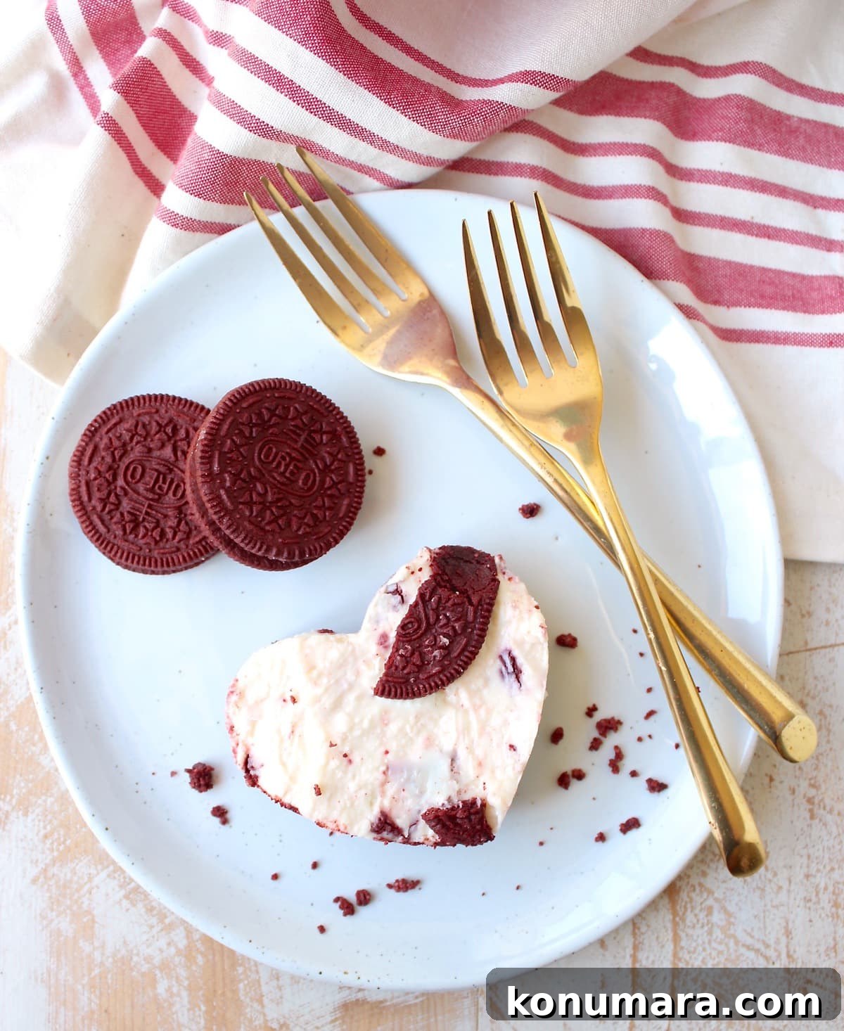 Red Velvet Oreo Cheesecake Bars Recipe 2 red velvet oreo cheesecake bar cut into a heart shape on a plate with gold forks
