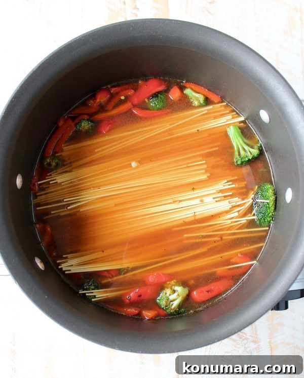 One Pot Teriyaki Shrimp Lo Mein Recipe 6 vegetables and noodles covered in broth in a large pot