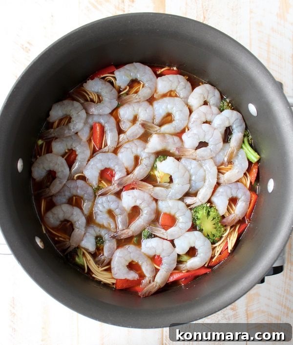 One Pot Teriyaki Shrimp Lo Mein Recipe 7 uncooked shrimp in a large pot on top of noodles and vegetables