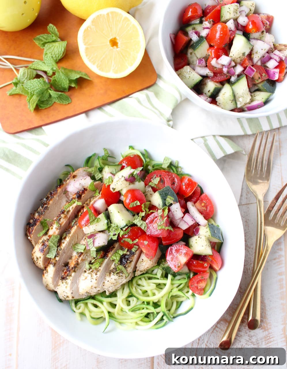 sliced grilled chicken in bowl with zucchini noodles and tomato cucumber salad