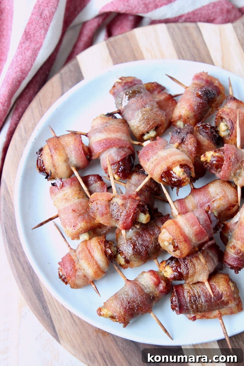 Bacon-Wrapped Dates Appetizer Recipe 3 Overhead shot of bacon wrapped dates skewered with toothpicks on white plate on top of wood cutting board