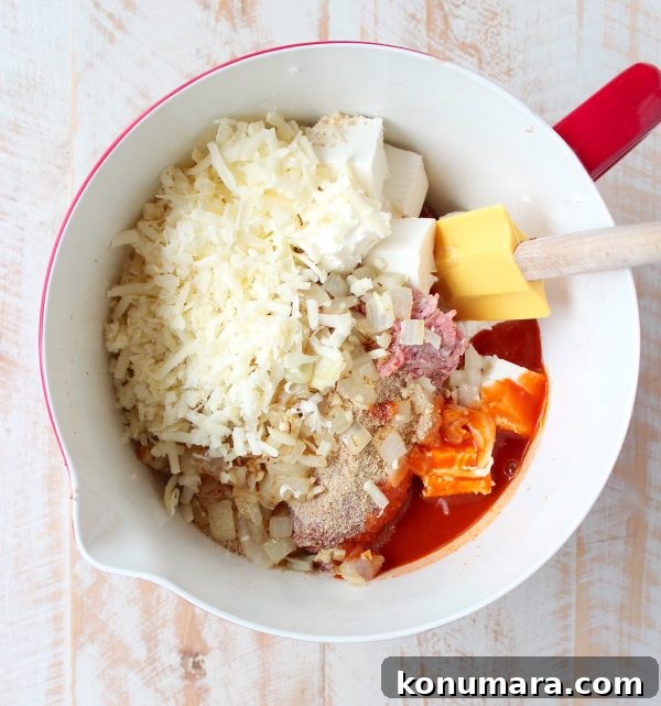 Buffalo-Style Cheesy Meatloaf Recipe 4 ingredients for buffalo cheesy meatloaf in large mixing bowl with spatula