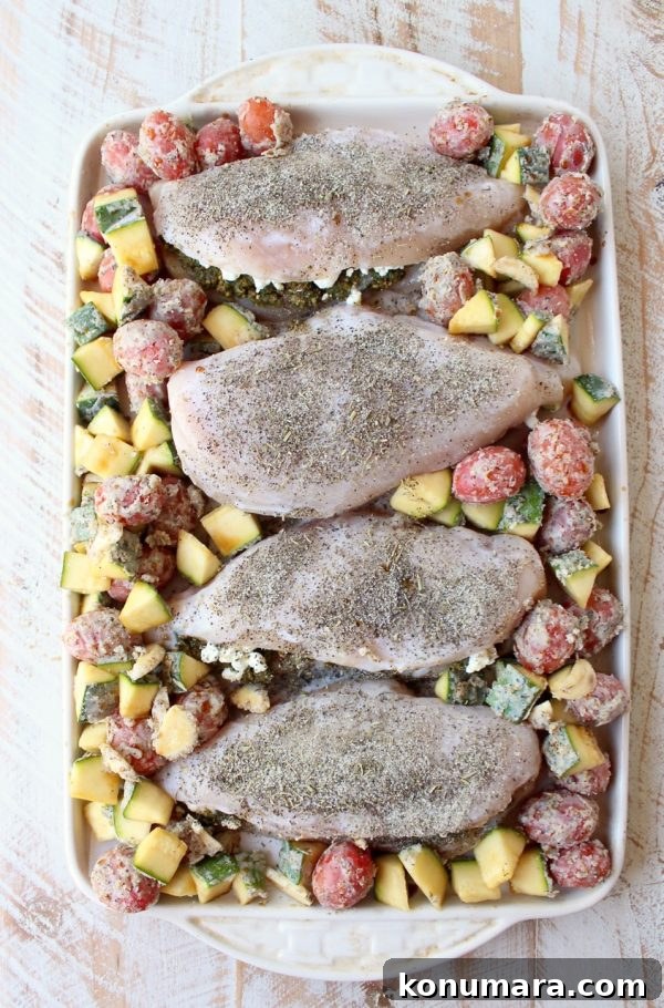 Sheet Pan Stuffed Chicken with Goat Cheese and Pesto 8 Vegetables placed around stuffed chicken before roasting