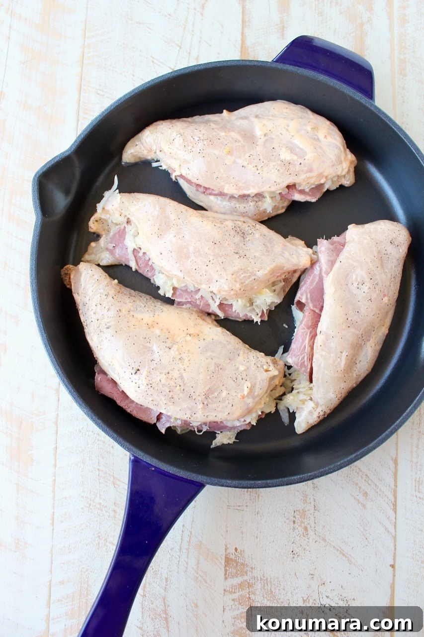 Reuben chicken is tossed with thousand island dressing, stuffed with sauerkraut & corned beef & topped with swiss cheese for a tasty, easy dinner recipe!