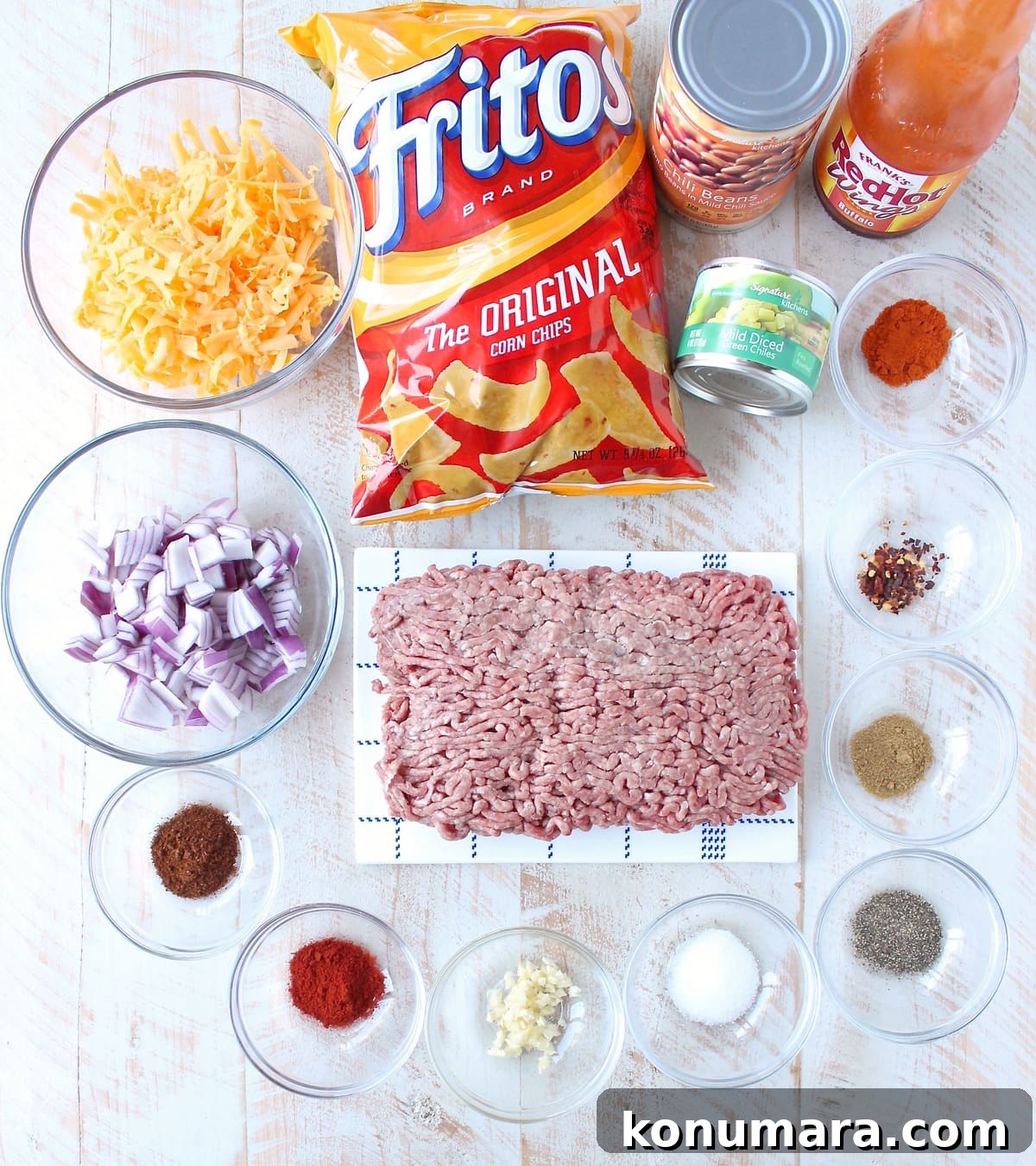 ingredients for frito chili pie on white wood board