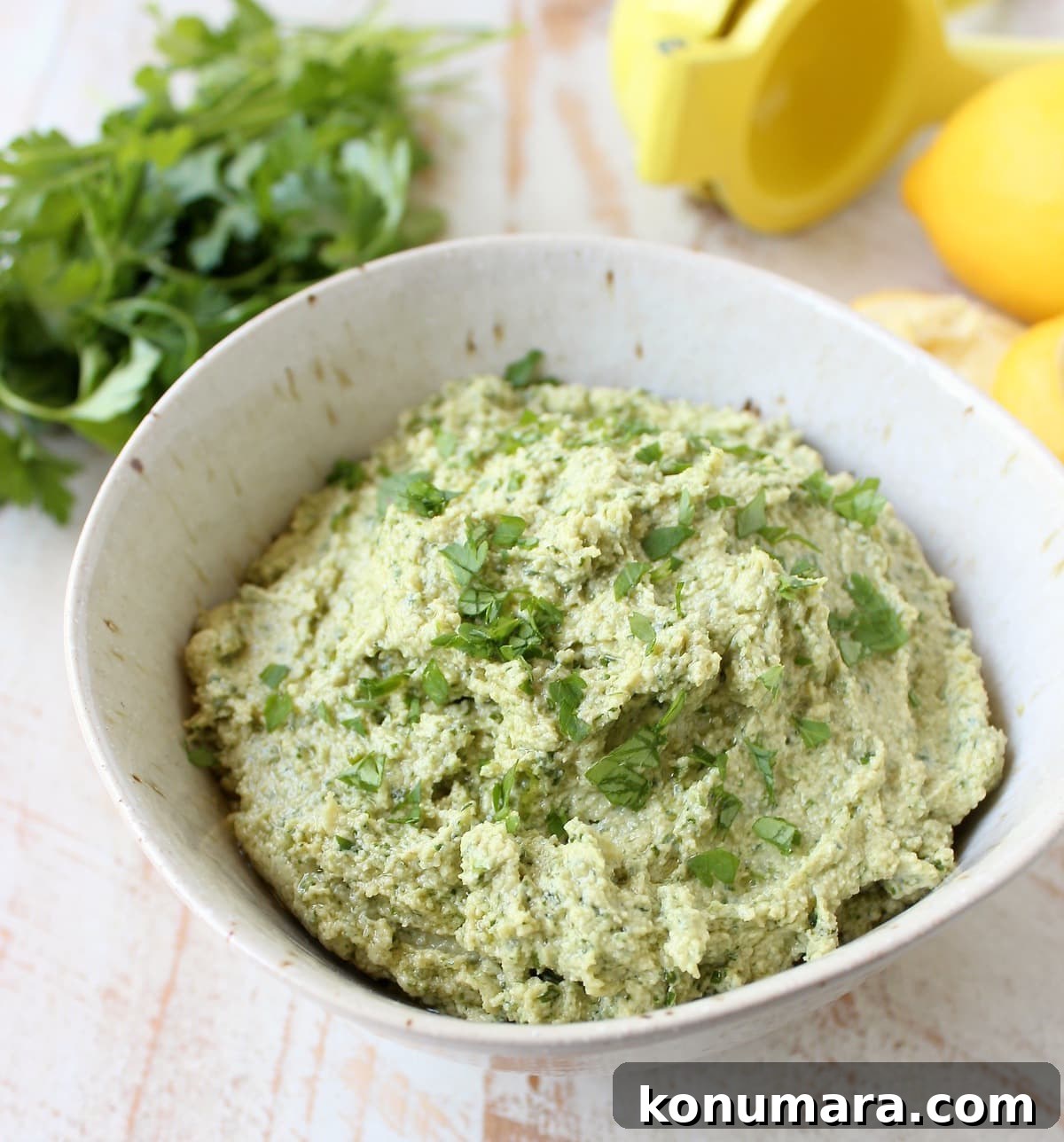 Green Tahini Sauce in a bowl with fresh herbs