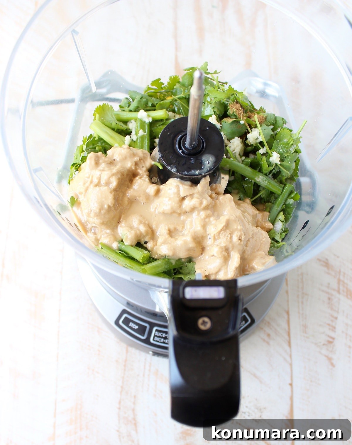 Jar of green tahini sauce with spoon