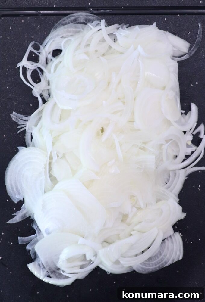 thinly sliced onions on cutting board