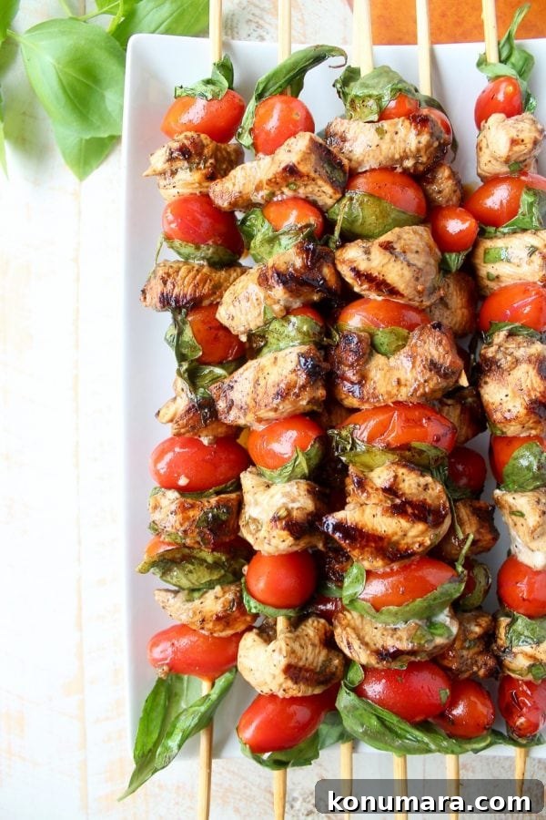 Tomato Basil Chicken Skewers plated with fresh basil