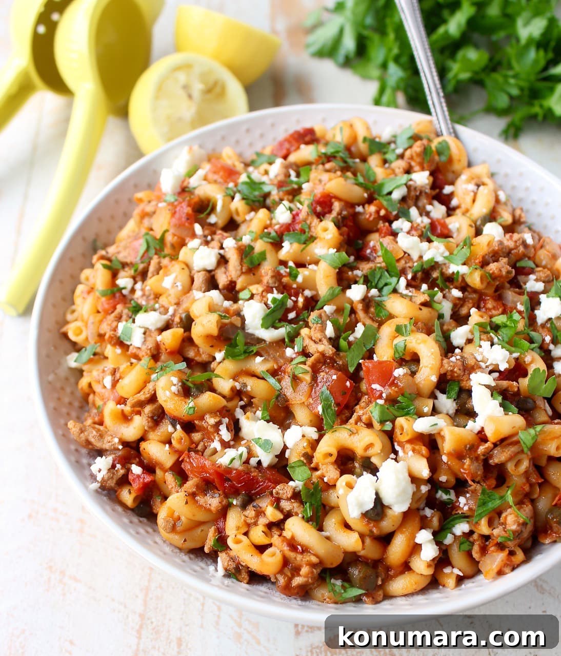 One-Pot Greek Pasta with Feta, Olives and Tomatoes 2 cooked pasta with ground turkey, tomatoes and feta cheese in white bowl