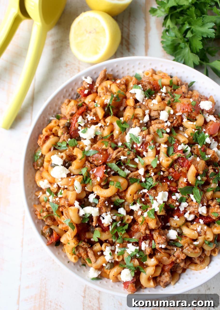 One-Pot Greek Pasta with Feta, Olives and Tomatoes 6 prepared greek pasta recipe in white bowl topped with fresh chopped parsley