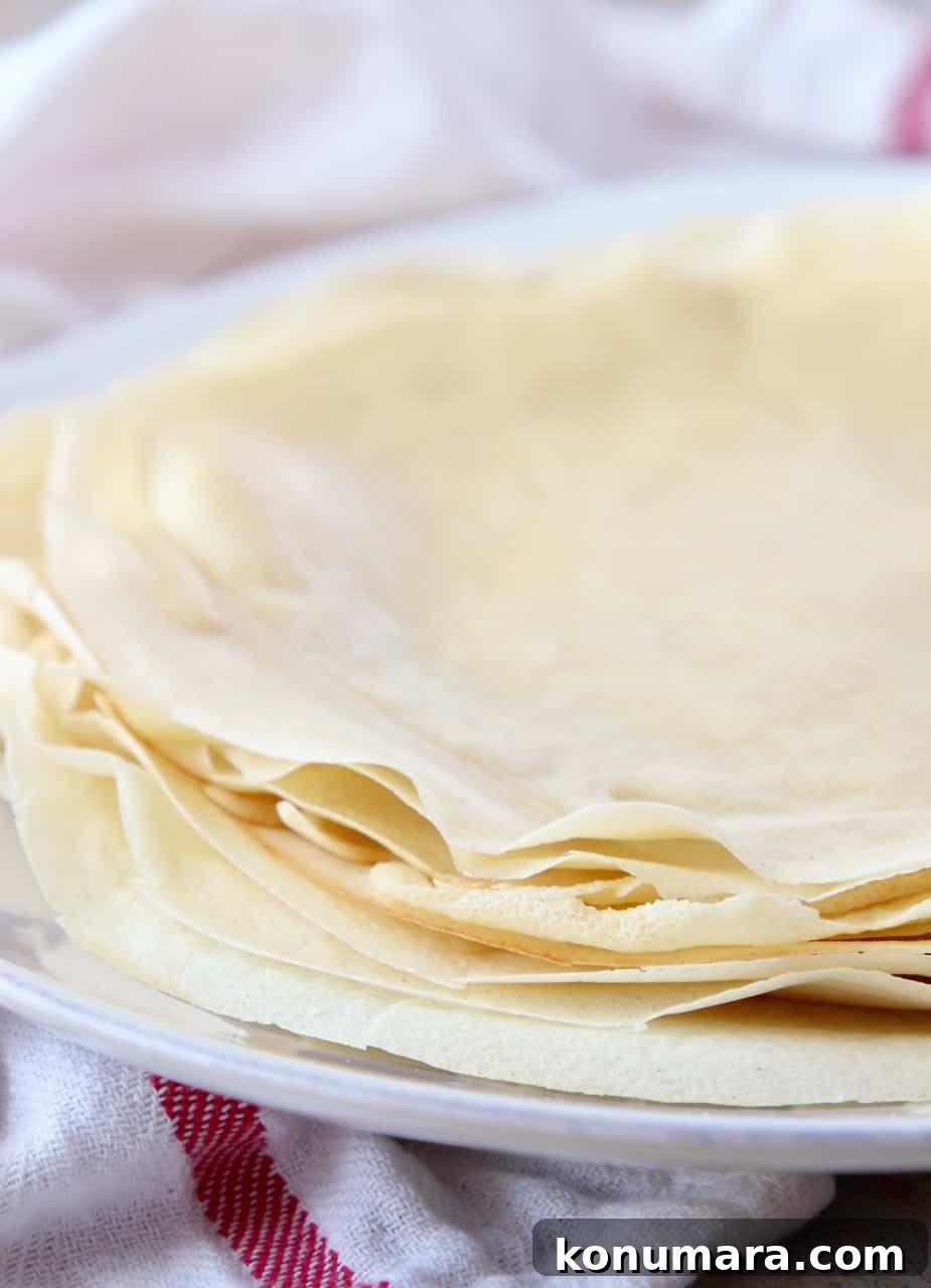 Classic French Crepes Recipe with Sweet and Savory Fillings 2 crepes stacked on top of each other on a plate