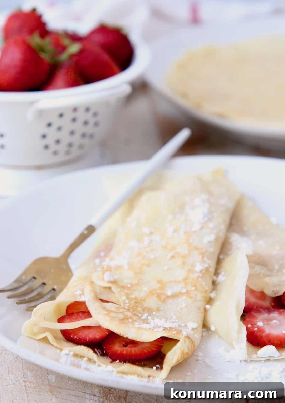 Classic French Crepes Recipe with Sweet and Savory Fillings 6 Nutella strawberry filled crepes on plate with fork