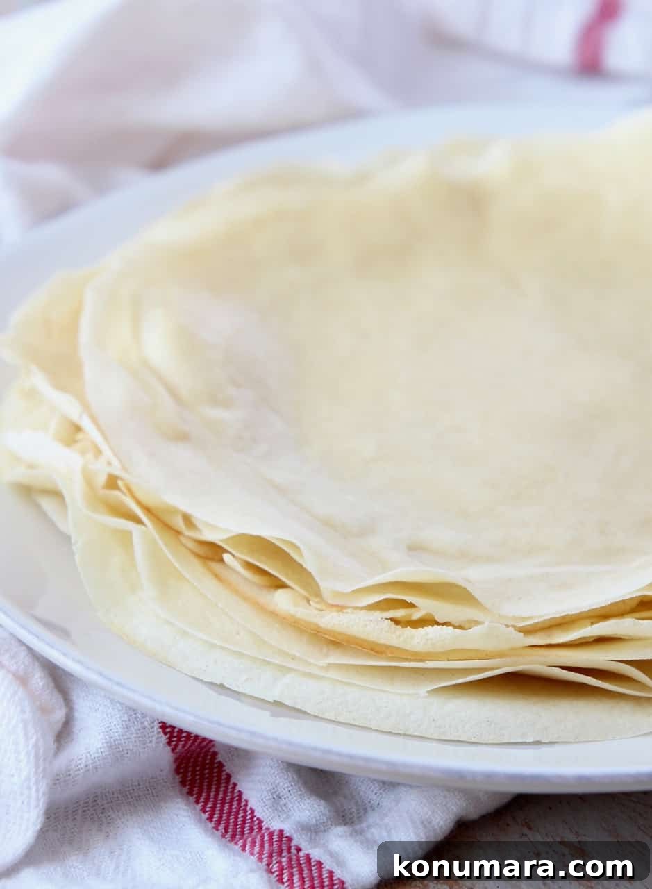 Classic French Crepes Recipe with Sweet and Savory Fillings 7 crepes stacked on top of each other on a plate