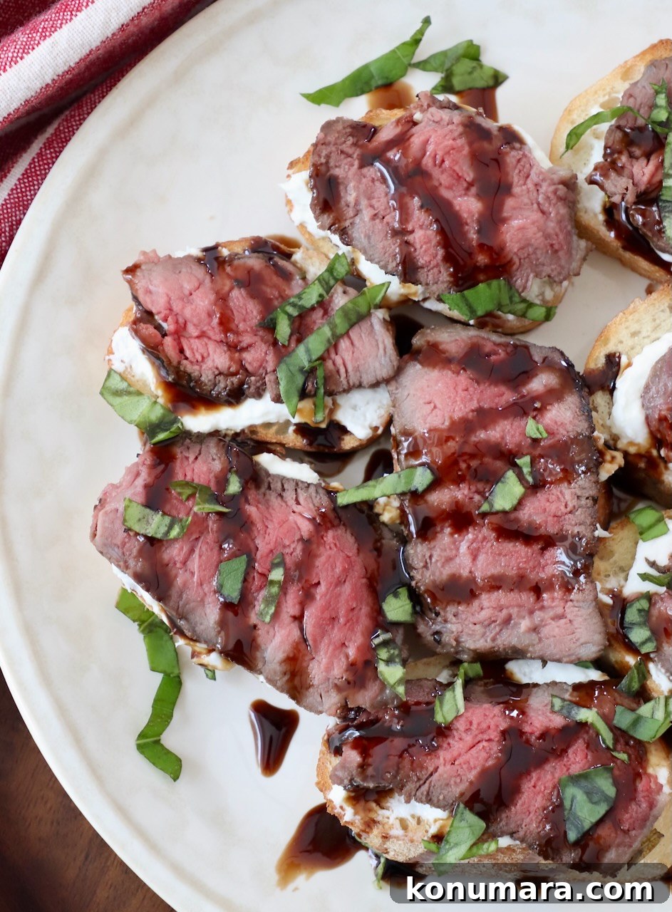 Seared Steak Crostini Recipe with Garlic Herb Butter 9 steak crostini topped with balsamic glaze on plate
