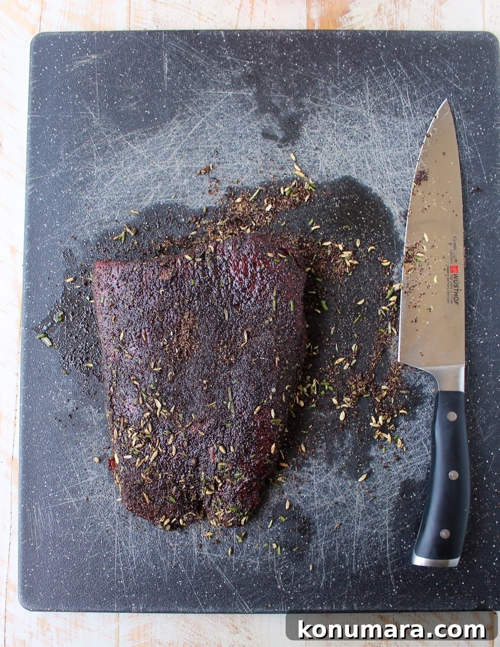 coffee rubbed skirt steak on cutting board with knife