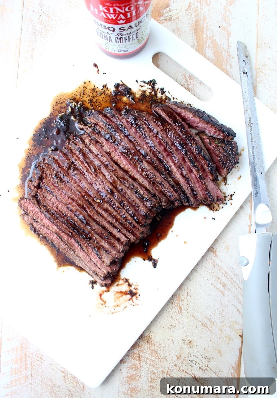 sliced steak on cutting board with electric knife on the side