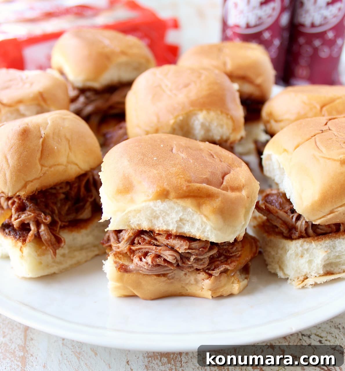 Hawaiian roll pulled pork sandwiches on a white plate.