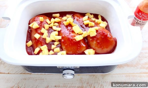 Hawaiian Chicken Sliders are easily made by tossing chicken, pineapple & Hawaiian BBQ sauce in a slow cooker for a few hours, then serving on Hawaiian rolls!