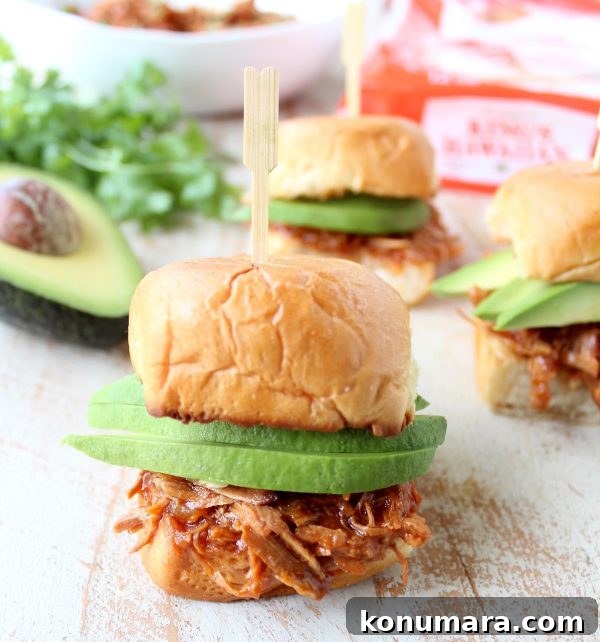 Hawaiian Chicken Sliders are easily made by tossing chicken, pineapple & Hawaiian BBQ sauce in a slow cooker for a few hours, then serving on Hawaiian rolls!