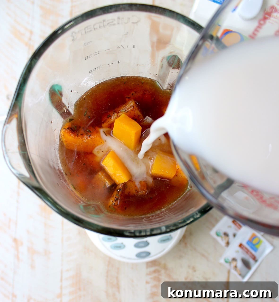 Almond milk poured into a blender with chai tea and roasted butternut squash